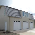 Exterior view of galvanized steel barndominiums in Perezville, Texas, showcasing modern design and rural landscaping