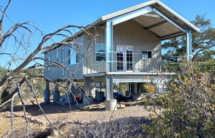 Rustic galvanized steel cabins in Evergreen, Colorado, surrounded by lush pine trees and mountain views