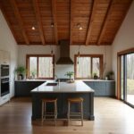 Modern farm-style barndominium kitchen featuring rustic wood beams and stainless steel appliances.