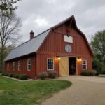 A detailed view of barn-style homes showcasing varying barndominium prices and architectural designs.