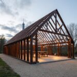 A modern steel frame barndominium showcasing its spacious layout and rustic charm amidst a scenic landscape.