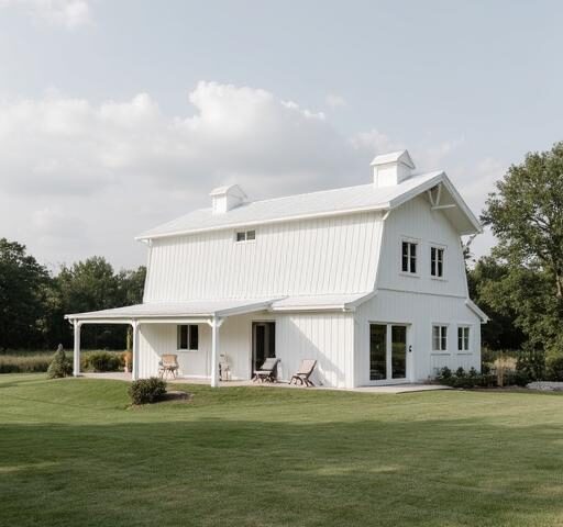 A stunning white barndominium featuring large windows and rustic charm amidst a lush landscape.